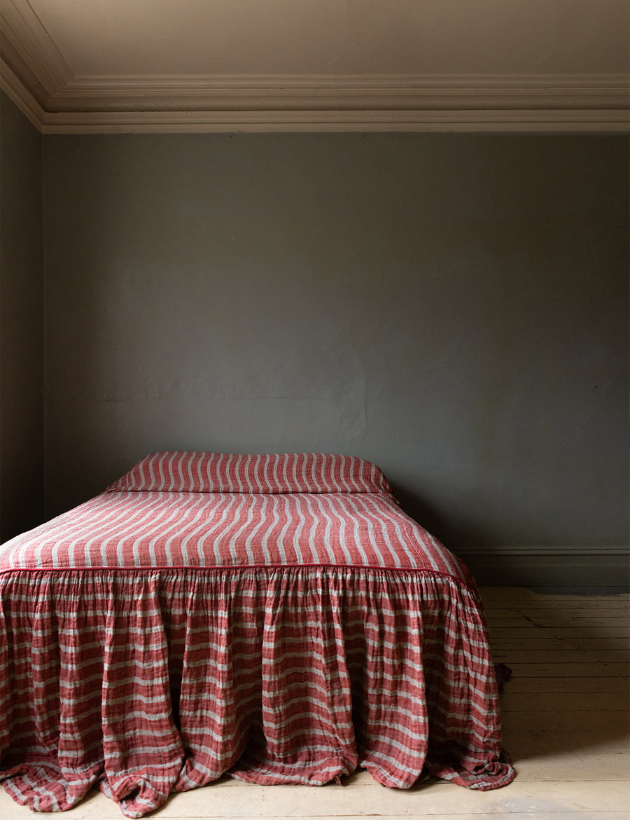 photoshoot of the red and natural striped linen bed cover