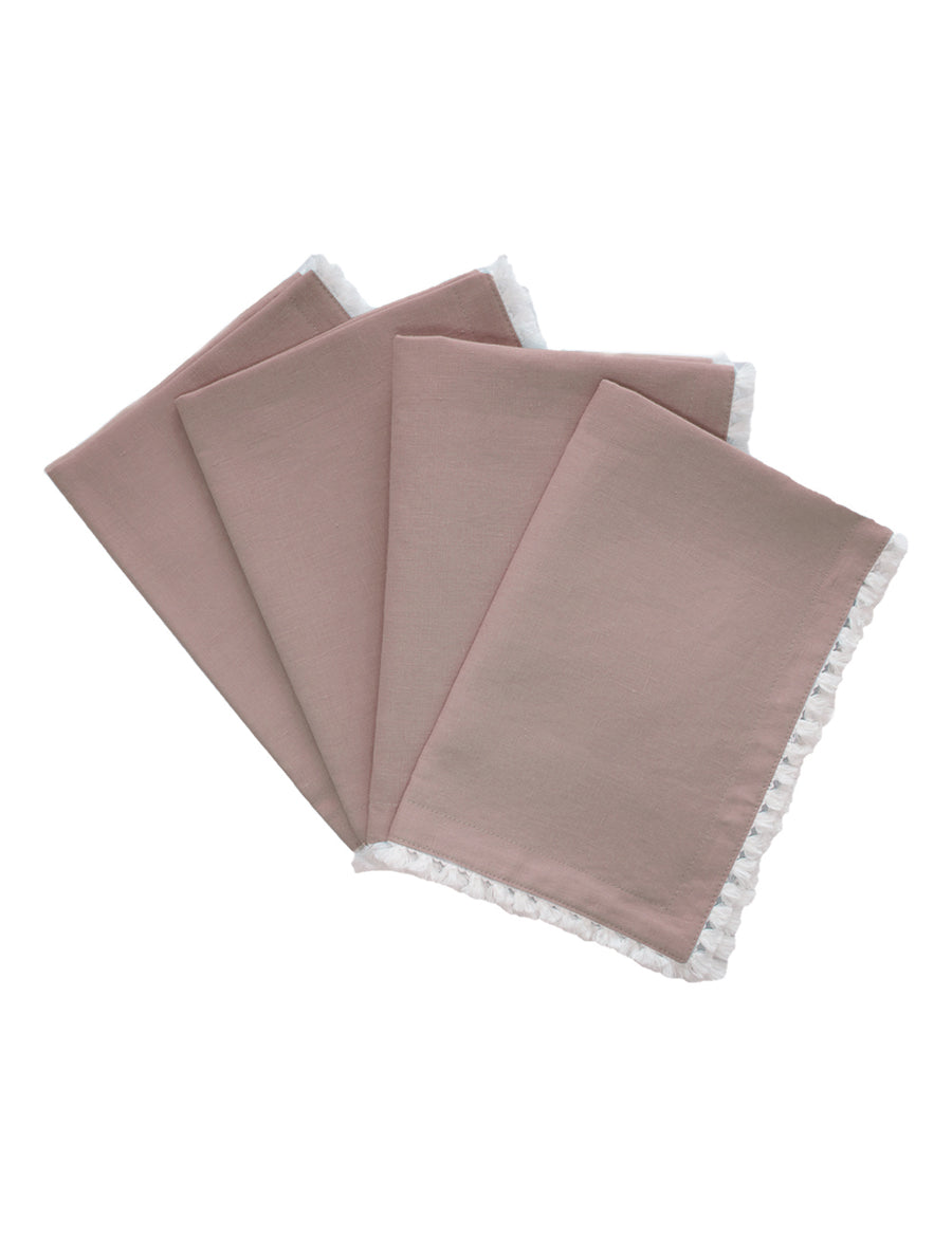 a set of linen placemat in blush colour with cotton tassel trim