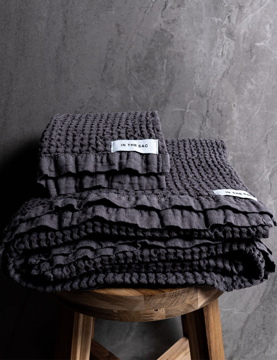 stacked linen waffle hand and bath towel in graphite colour