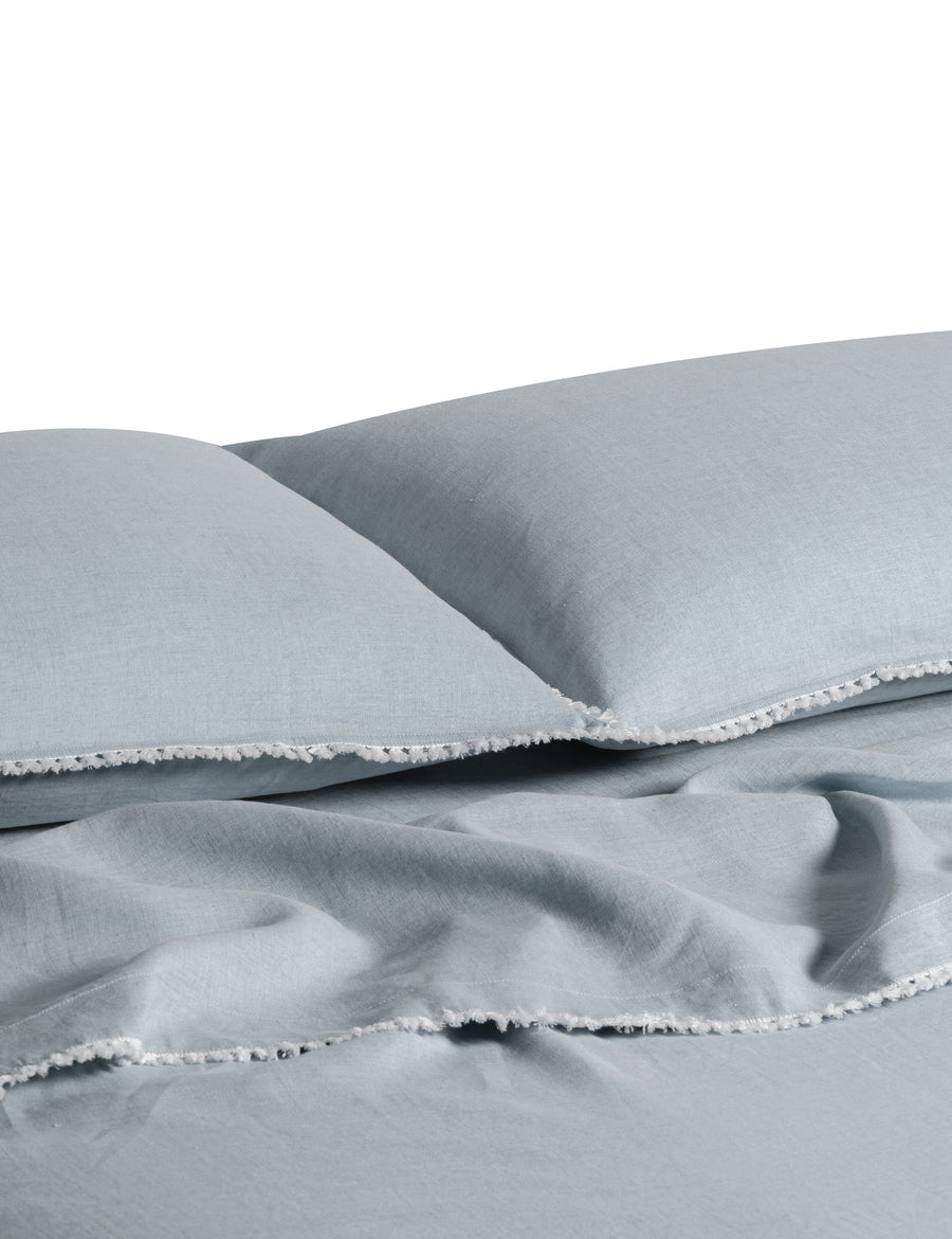 linen sheet set in cloud colour and finished in our contrast organic cotton tassel trim