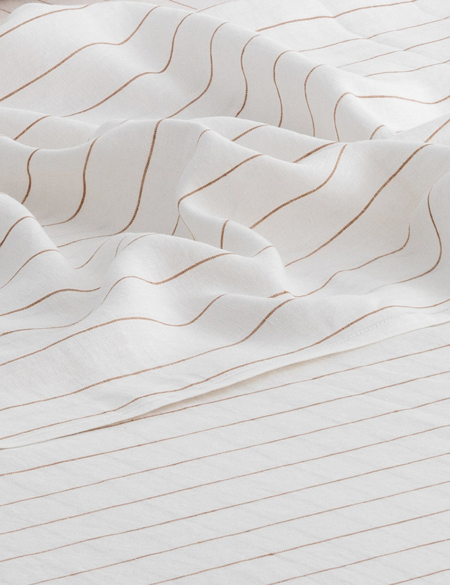 details of pinstripe linen sheet set in white with teak stripes