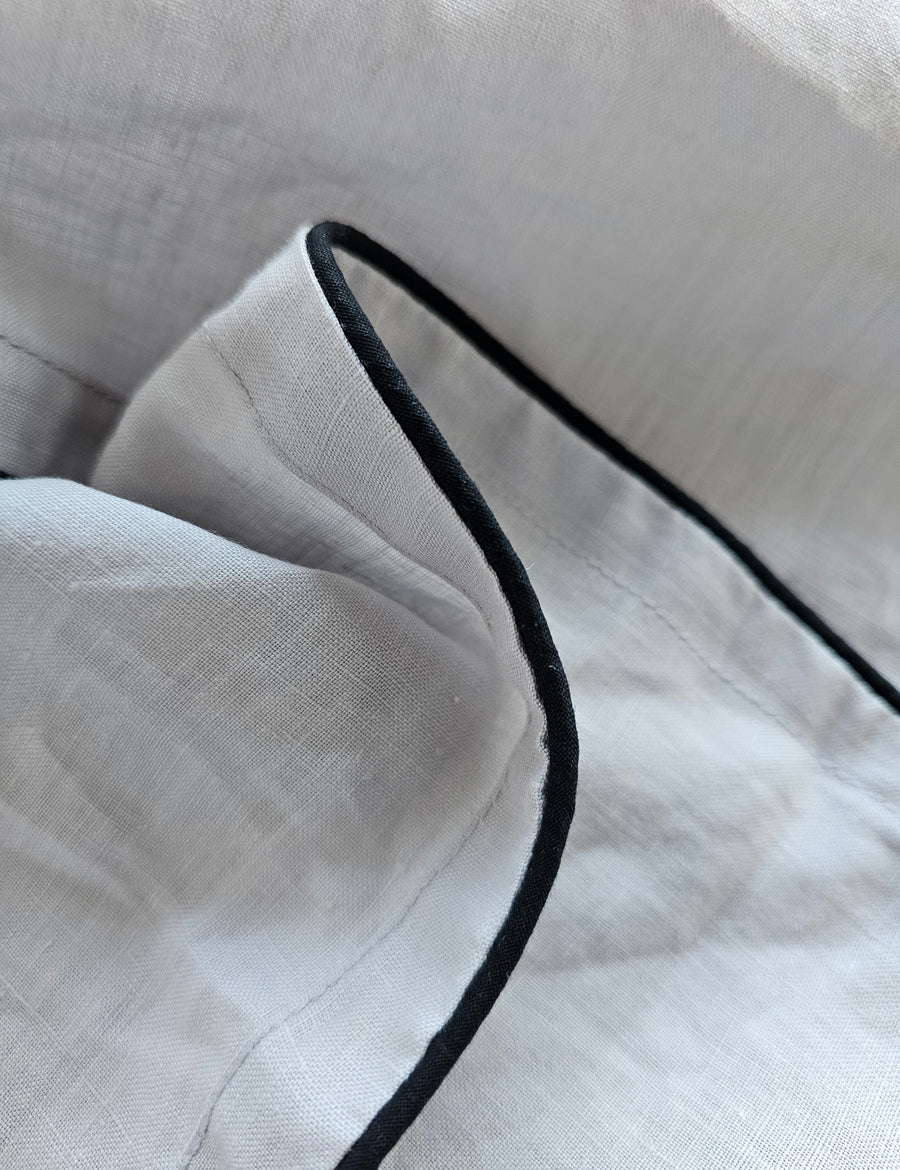 detail shot of the linen table napkins in cement colour with charcoal piping