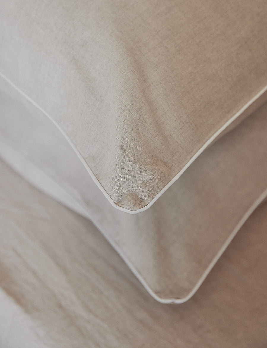 details of piped pillowcases in natural colour with contrast piping in white