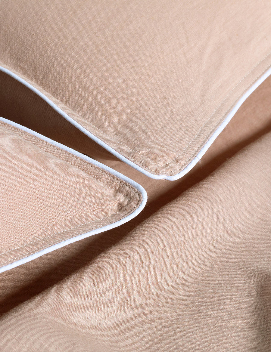 details of piped pillowcases in blush colour with contrast piping in white
