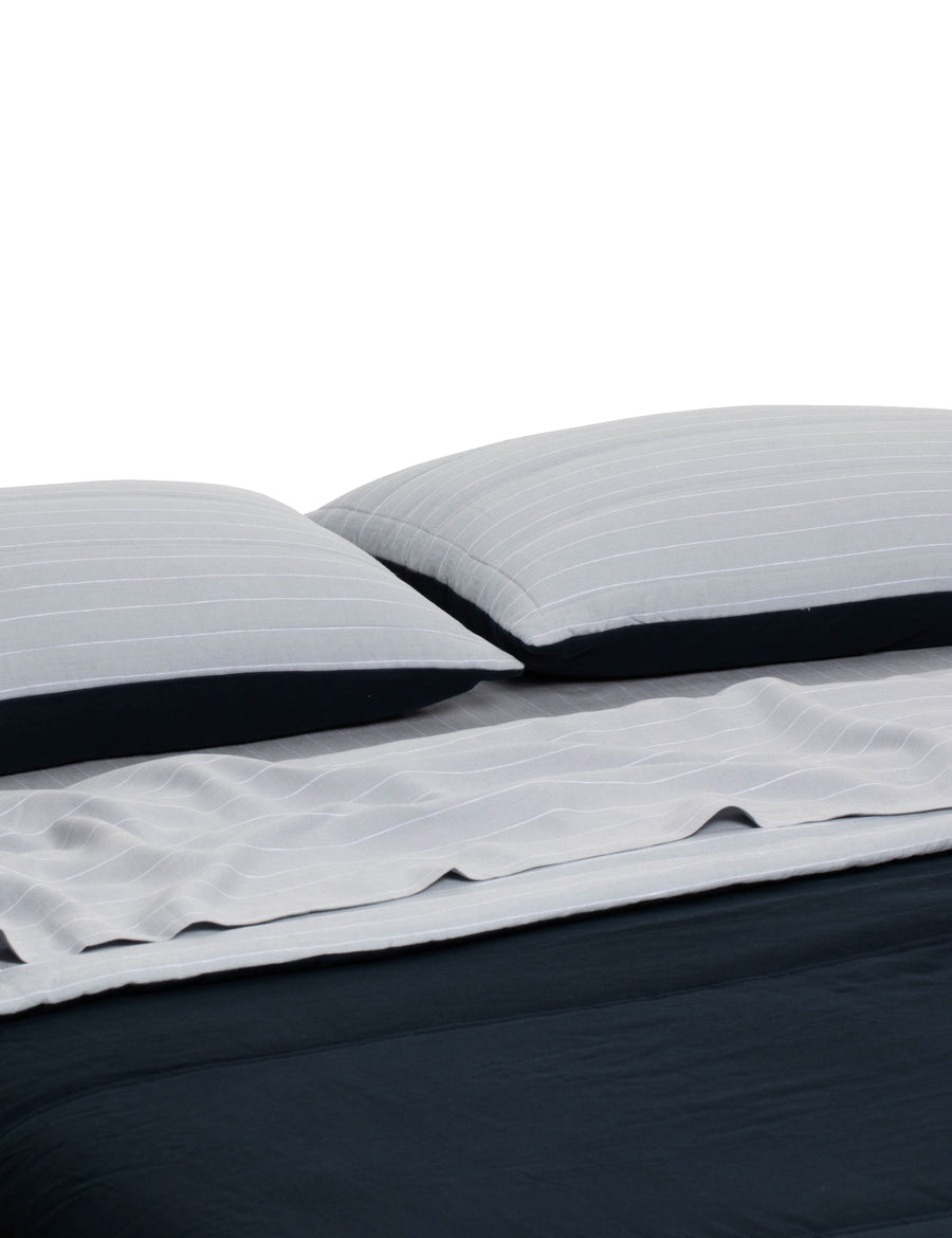 luxurious reversible quilted coverlets in navy and cloud pinstripe colour