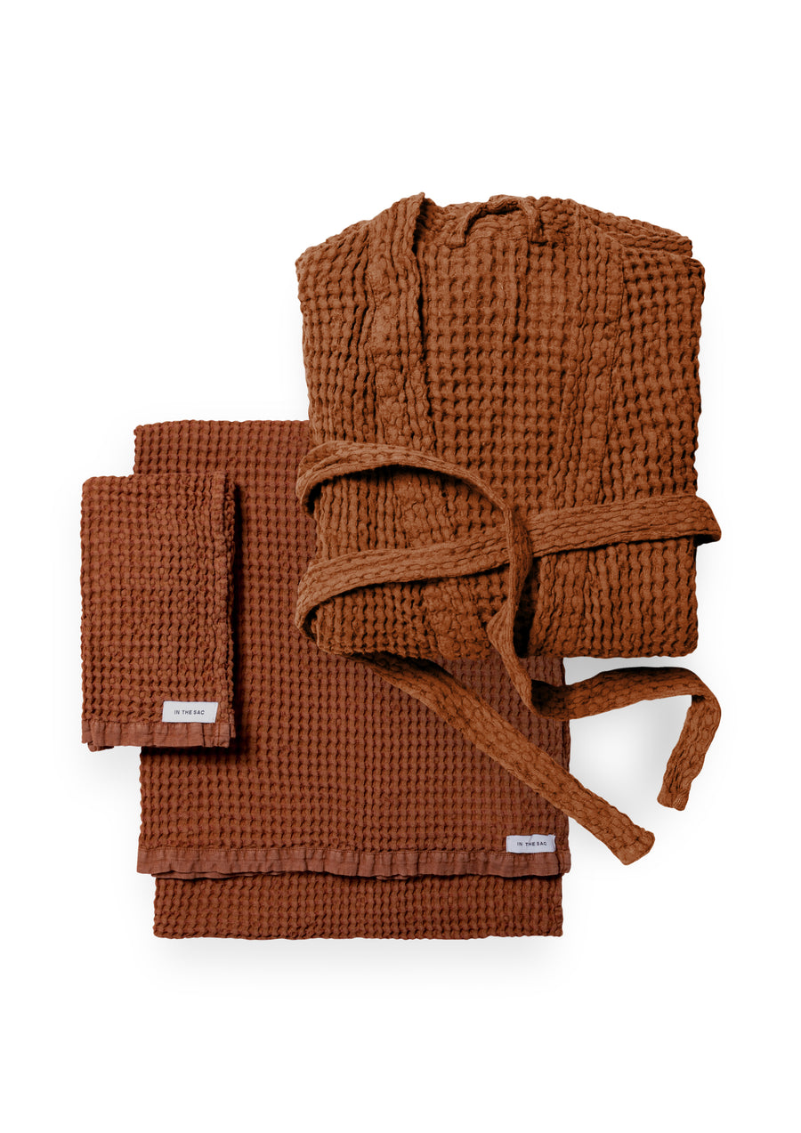 bundle photo of the linen waffle hand towel, bath towel and bath robe in rust colour