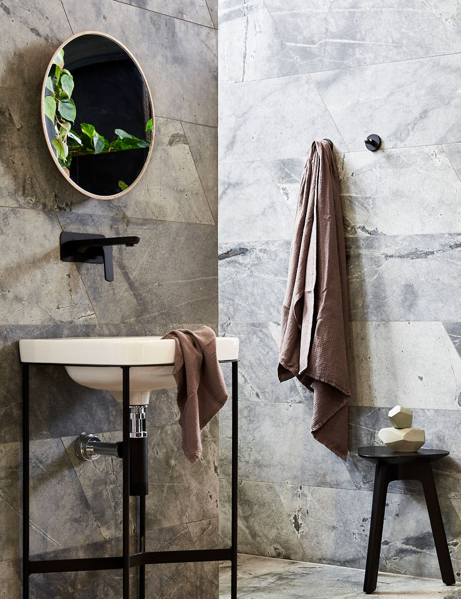 styled hanging pure linen jacquard bath towel in musk colour with matching hand towel in a modern bathroom