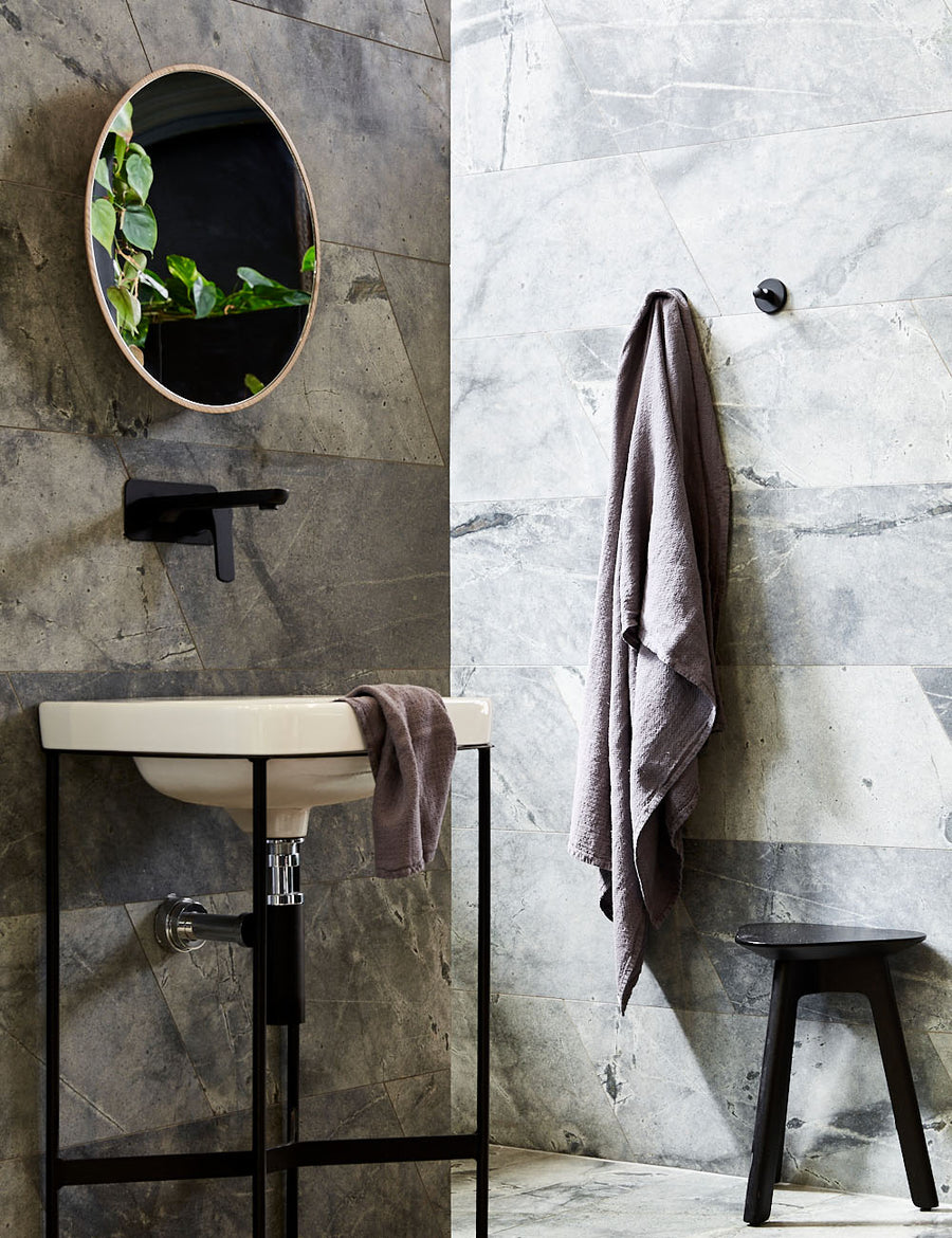 styled hanging pure linen jacquard bath towel in graphite colour with matching hand towel in a modern bathroom