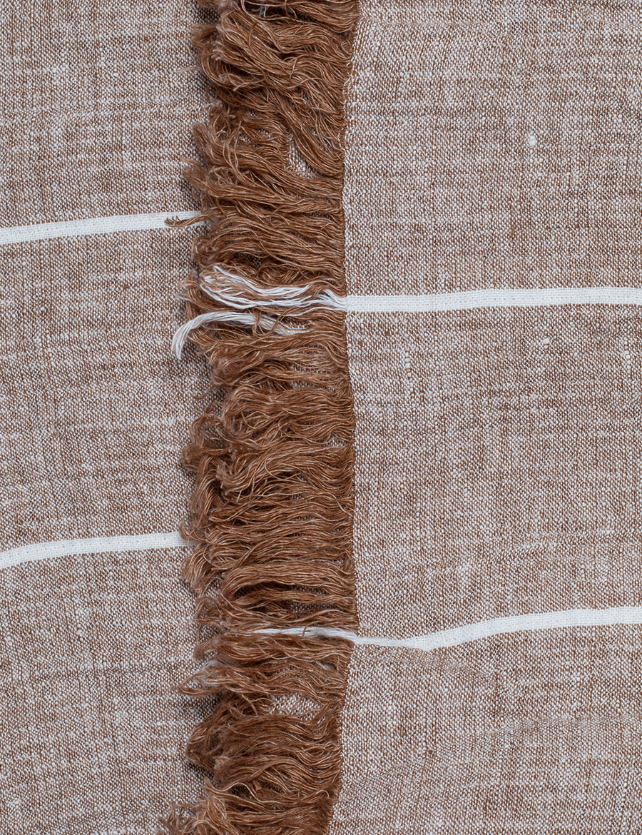 detail shot of textured linen throw with fringe trim in stripes caramel with natural