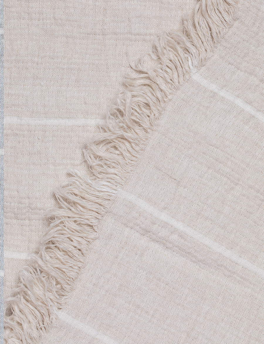 detail shot of textured linen throw with fringe trim in stripes natural with ivory