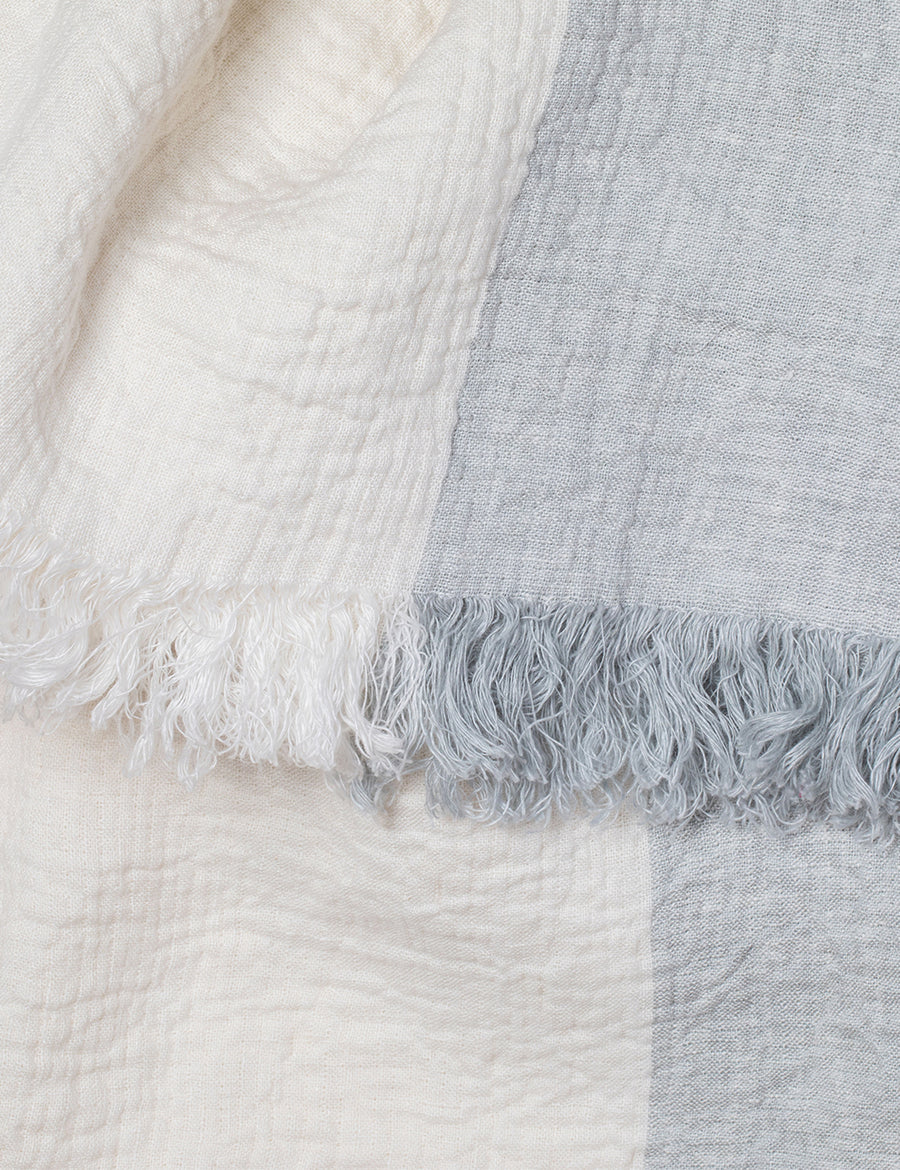 detail shot of textured linen throw with fringe trim in colour block cloud with ivory