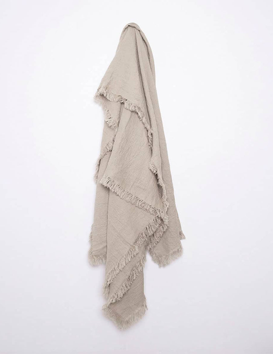 hanging photo of textured linen throw with fringe trim in natural colour