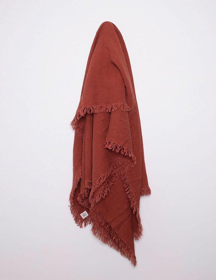 hanging photo of textured linen throw with fringe trim in rust colour
