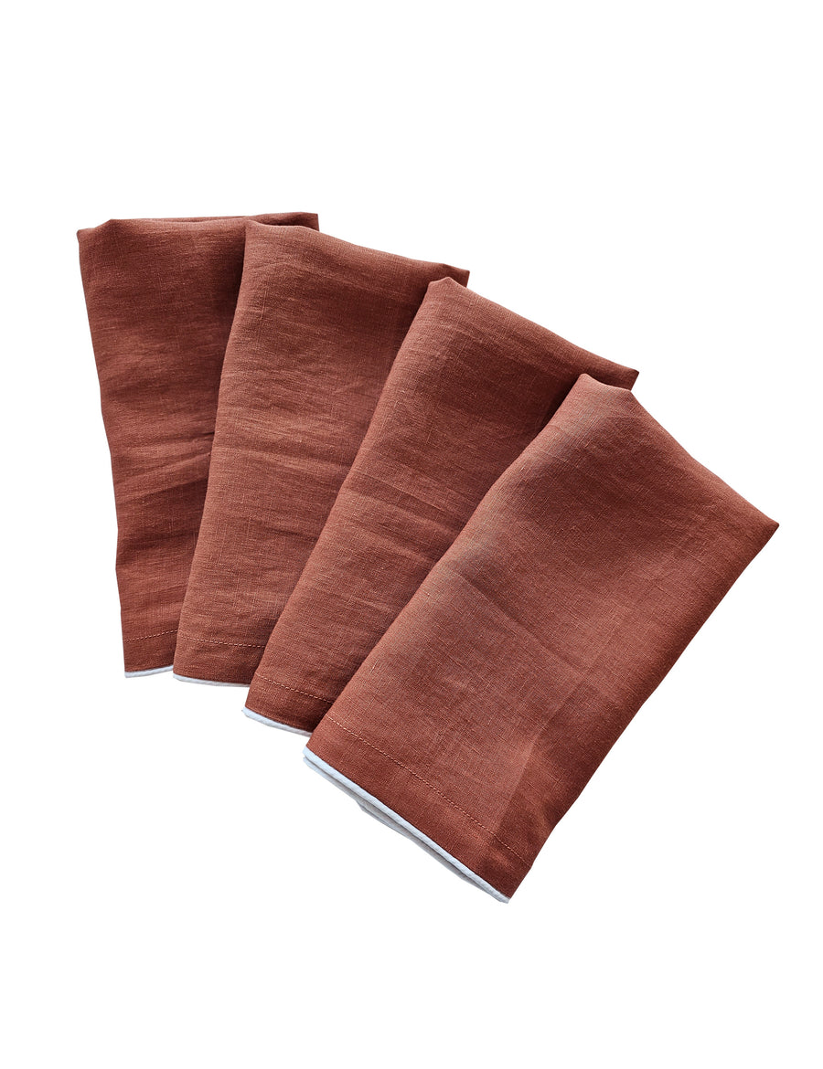 linen table napkins in rust colour with white piping