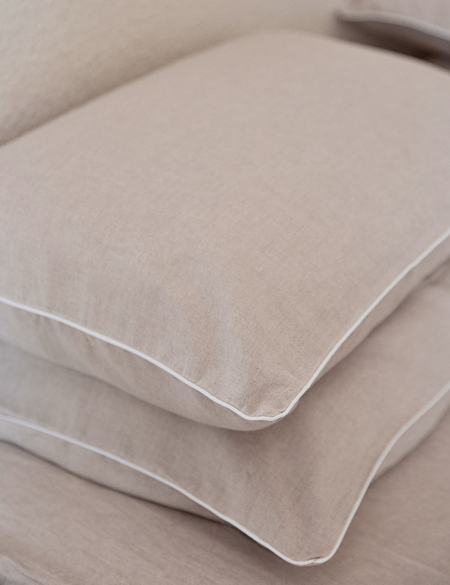 detail shot of the natural with white piping pillowcases