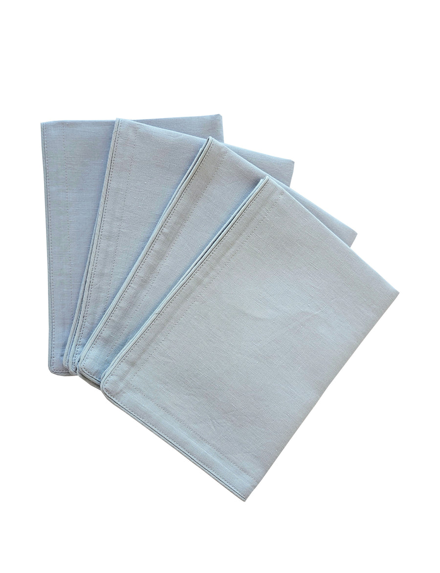 a set of piped linen placemat in cloud colour