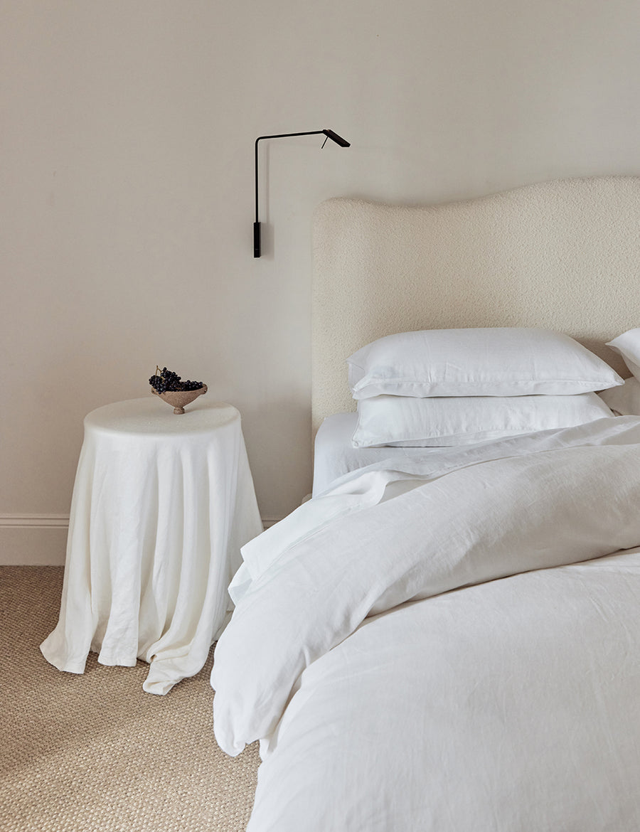 minimalistic photography of the linen piped sheet set in white with white piping details