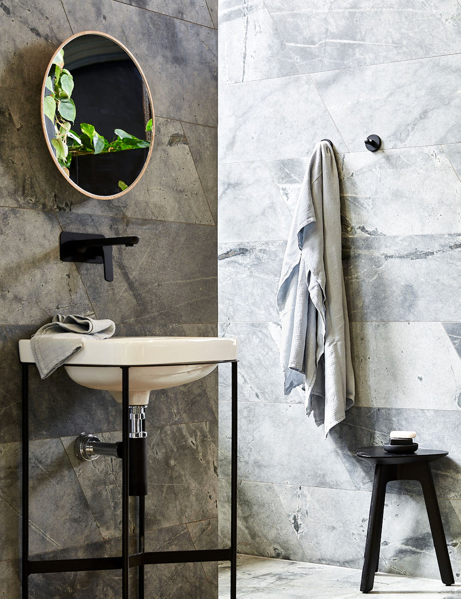 styled hanging pure linen jacquard bath towel in grey colour with matching hand towel in a modern bathroom