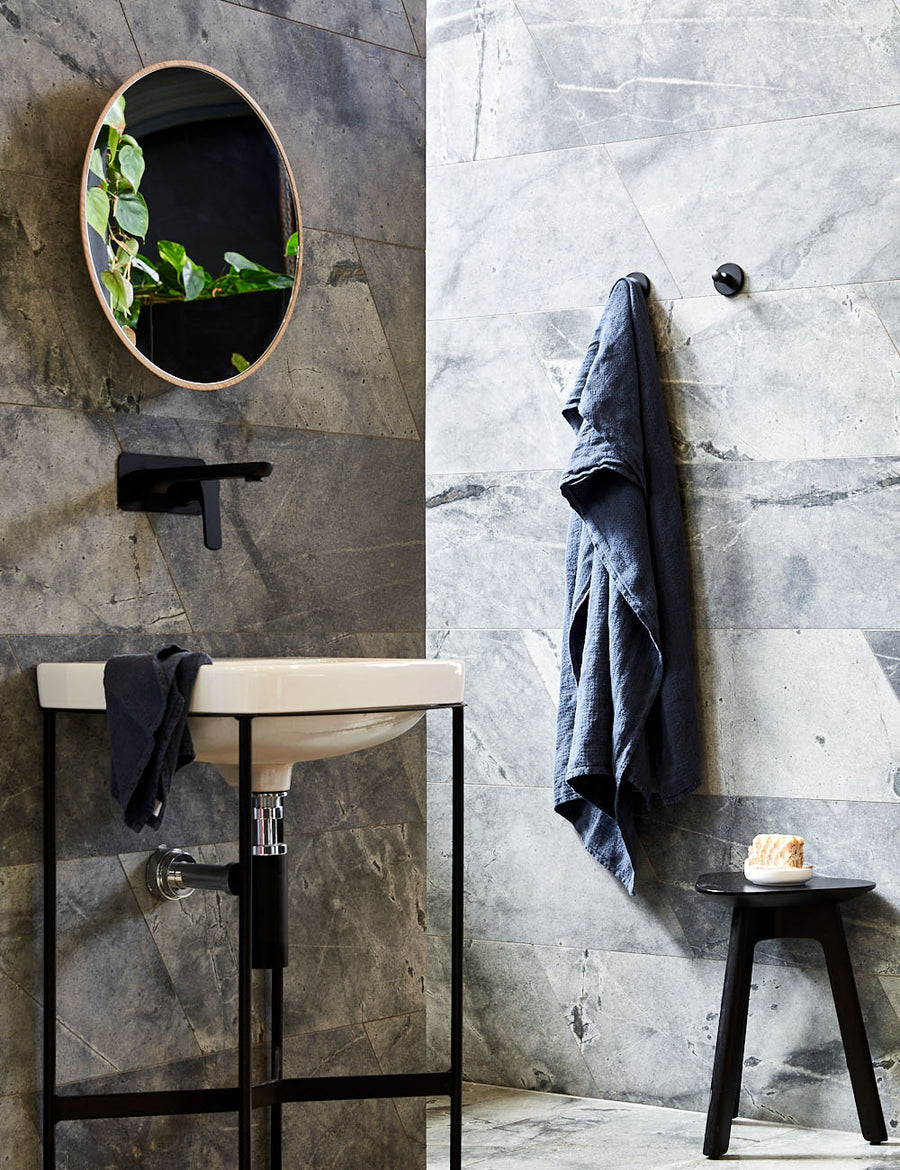 styled hanging pure linen jacquard bath towel in denim colour with matching hand towel in a modern bathroom