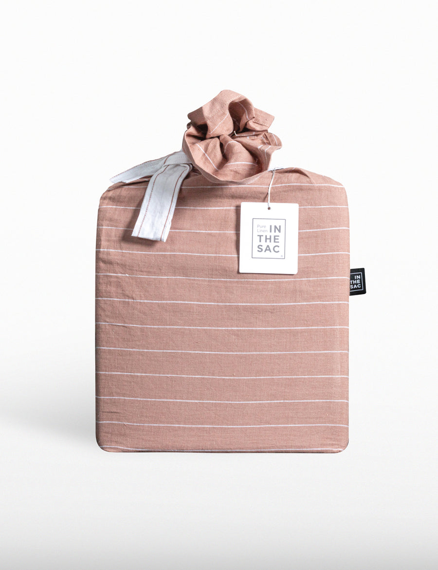 the packaging of reversible pinstripe linen quilt set in nude and white