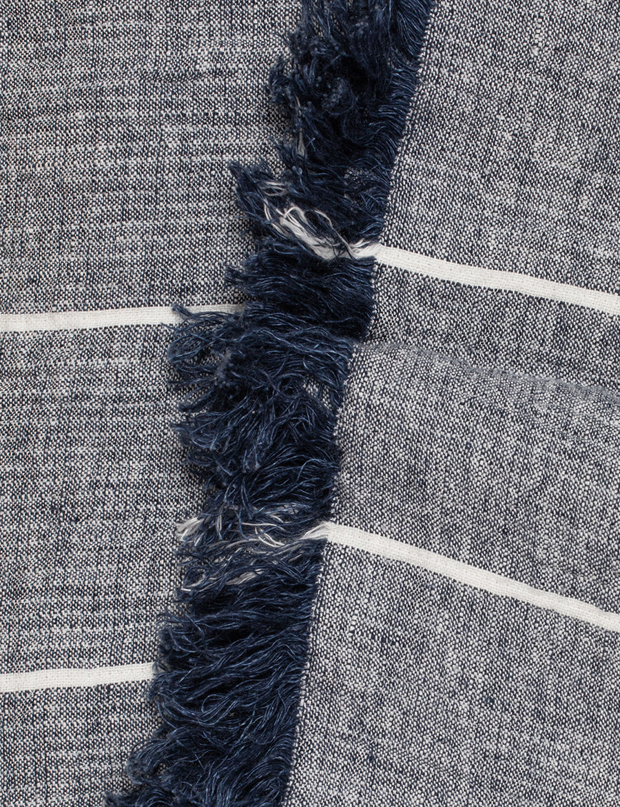 detail shot of textured linen throw with fringe trim in stripes navy with ivory