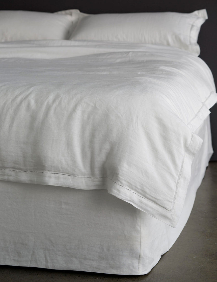 thick linen bed valance in white colour styled with linen quilt set in white