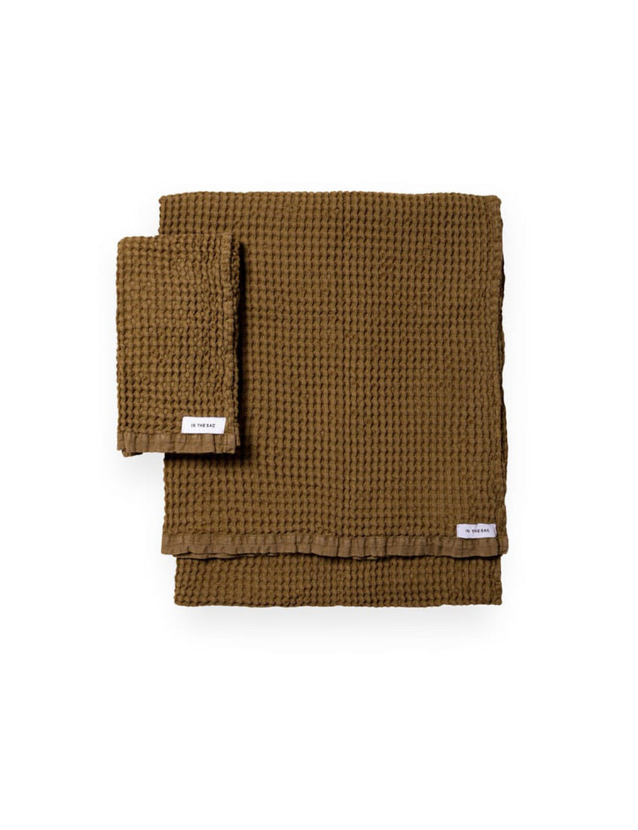 stacked photo of linen waffle hand towel in olive colour with matching bath towel
